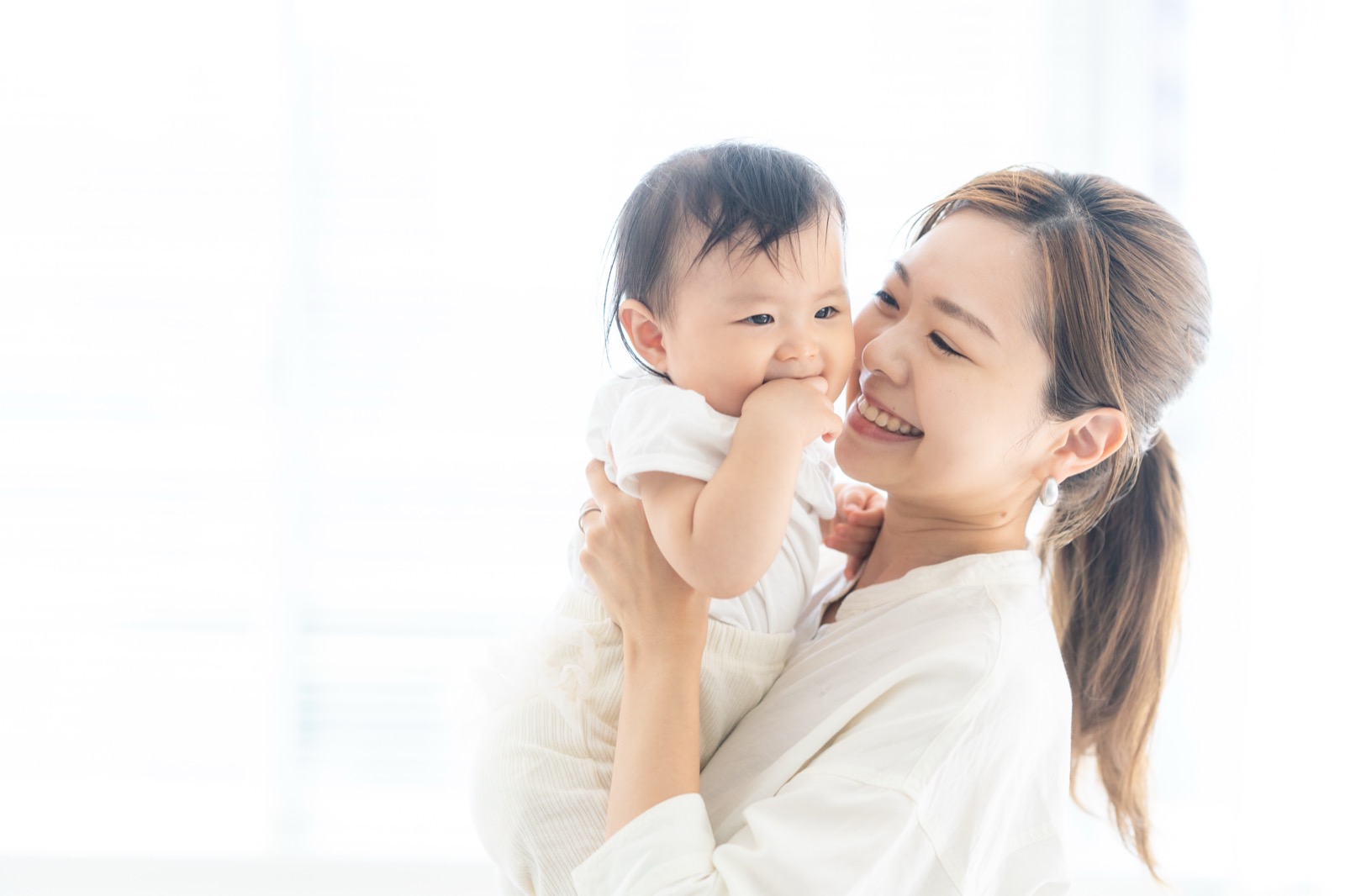 赤ちゃんを抱いて笑う母親